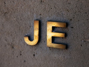 caption: Jeffrey Epstein's monogram is displayed on the exterior of his house on New York City's Upper East Side. On Tuesday, nearly three weeks after the financier took his own life in jail, victims of his alleged sex trafficking operation told their stories in a Manhattan courtroom.