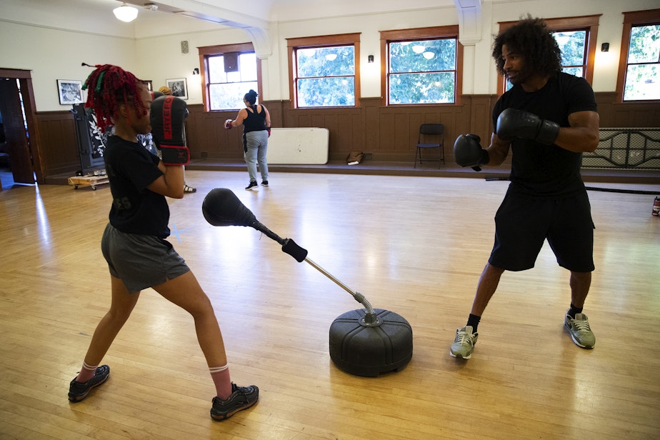 caption: Instructor Darnell Hill, right, boxes with Sky Muse, 21, left, during class on Wednesday, July 17, 2024, at Washington Hall in Seattle.