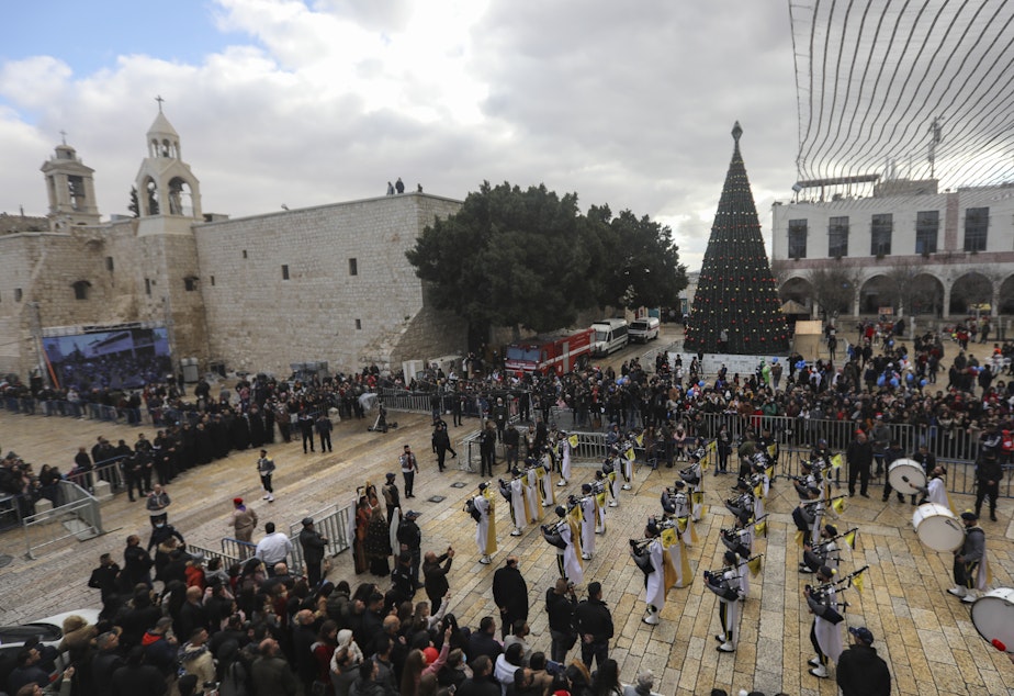 caption: Palestinian scout bands parade through Manger Square at the Church of the Nativity, traditionally believed to be the birthplace of Jesus Christ, during Christmas celebrations, in the West Bank town of Bethlehem on Friday.
