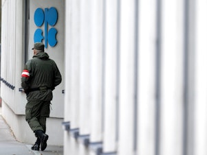 caption: An Austrian soldier guards the entrance of the OPEC headquarters in Vienna on October 4, on the eve of the 45th Meeting of the Joint Ministerial Monitoring Committee and the 33rd OPEC and non-OPEC Ministerial Meeting. OPEC and its allies agreed to reduce their production quotas at that meeting.