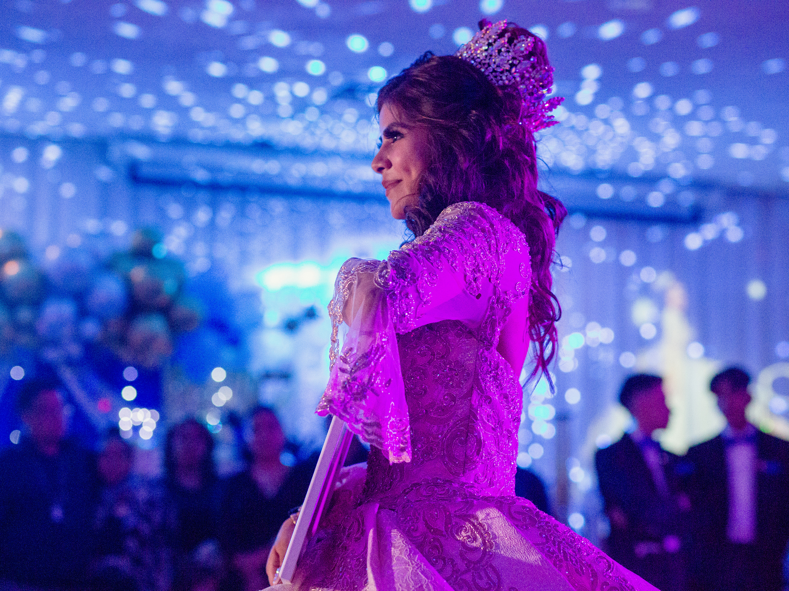 caption: Citlaly Olvera Salazar dances with an image of her grandfather, Antonio Salazar, and father, Cesar Olvera, in their absence during her Quinceañera.