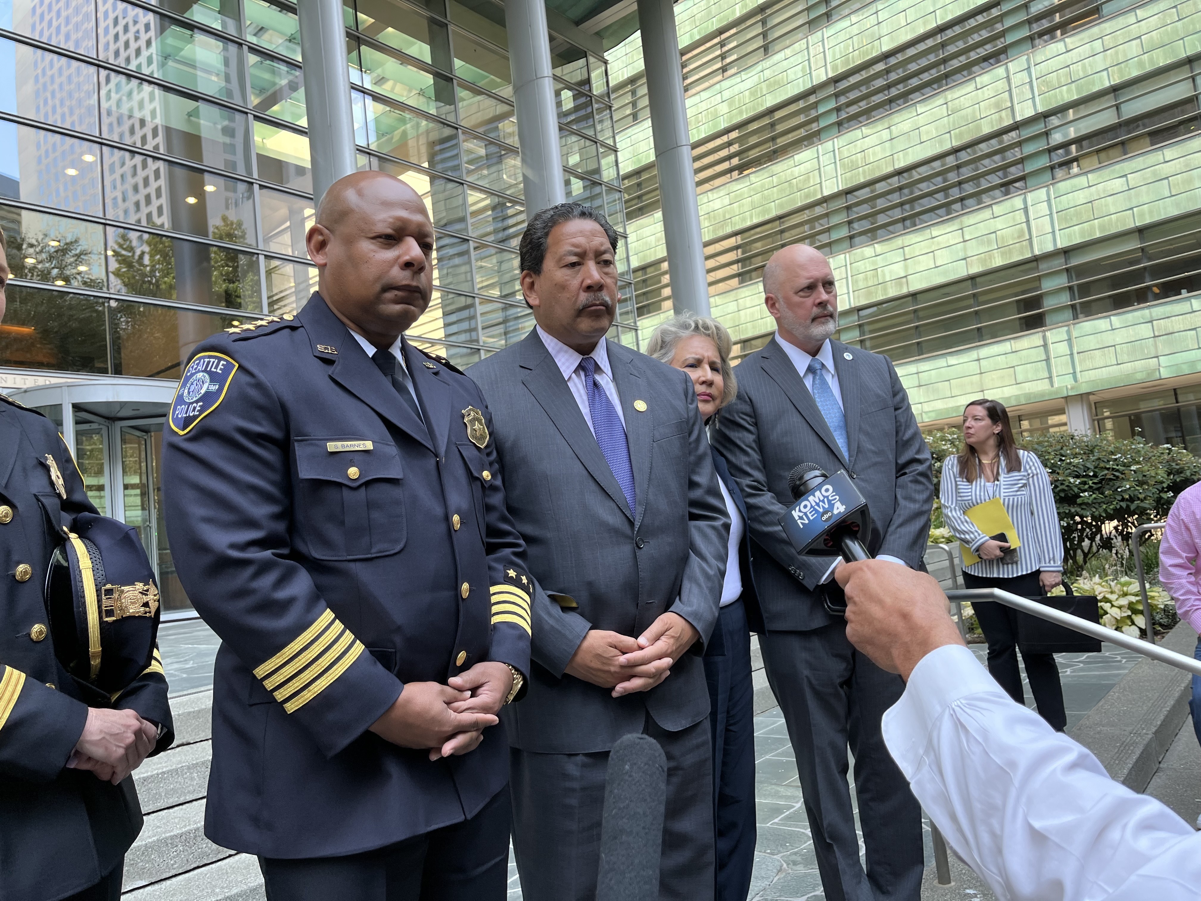 caption: Seattle officials including SPD Chief Shon Barnes, left, and Mayor Bruce Harrell, center, said they are eager to resume local control of SPD as they left the federal courthouse on Sept. 3, 2025.