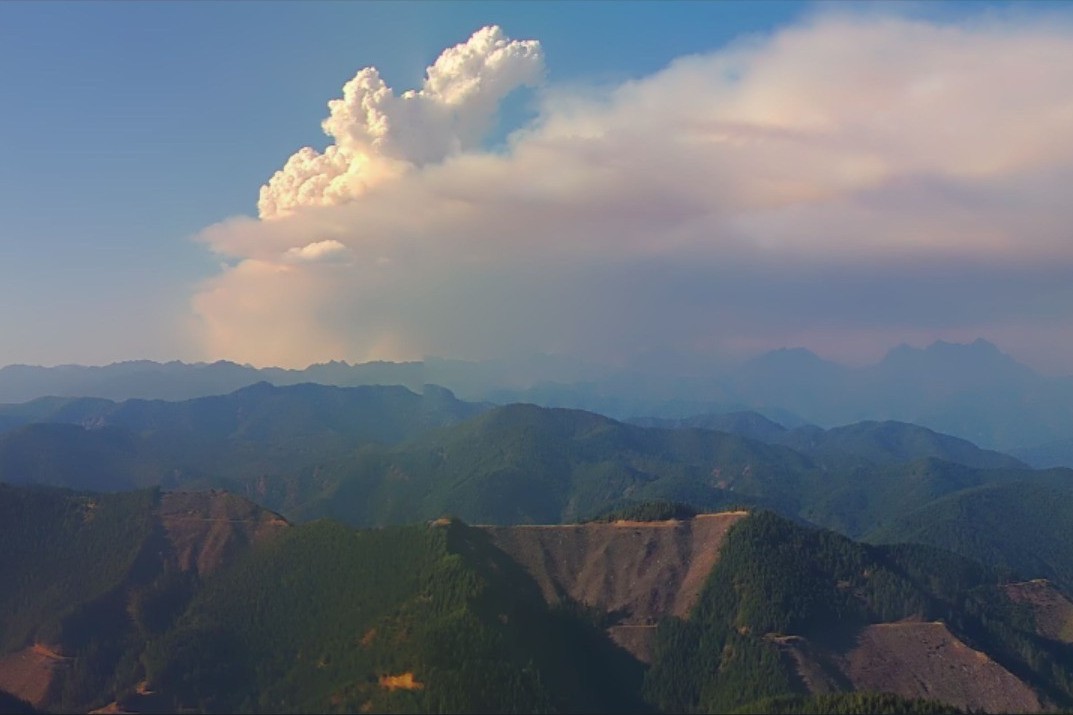 caption: A pyrocumulus cloud billows above smoke from the Bear Gulch Fire on the Olympic Peninsula on Aug. 12, 2025.