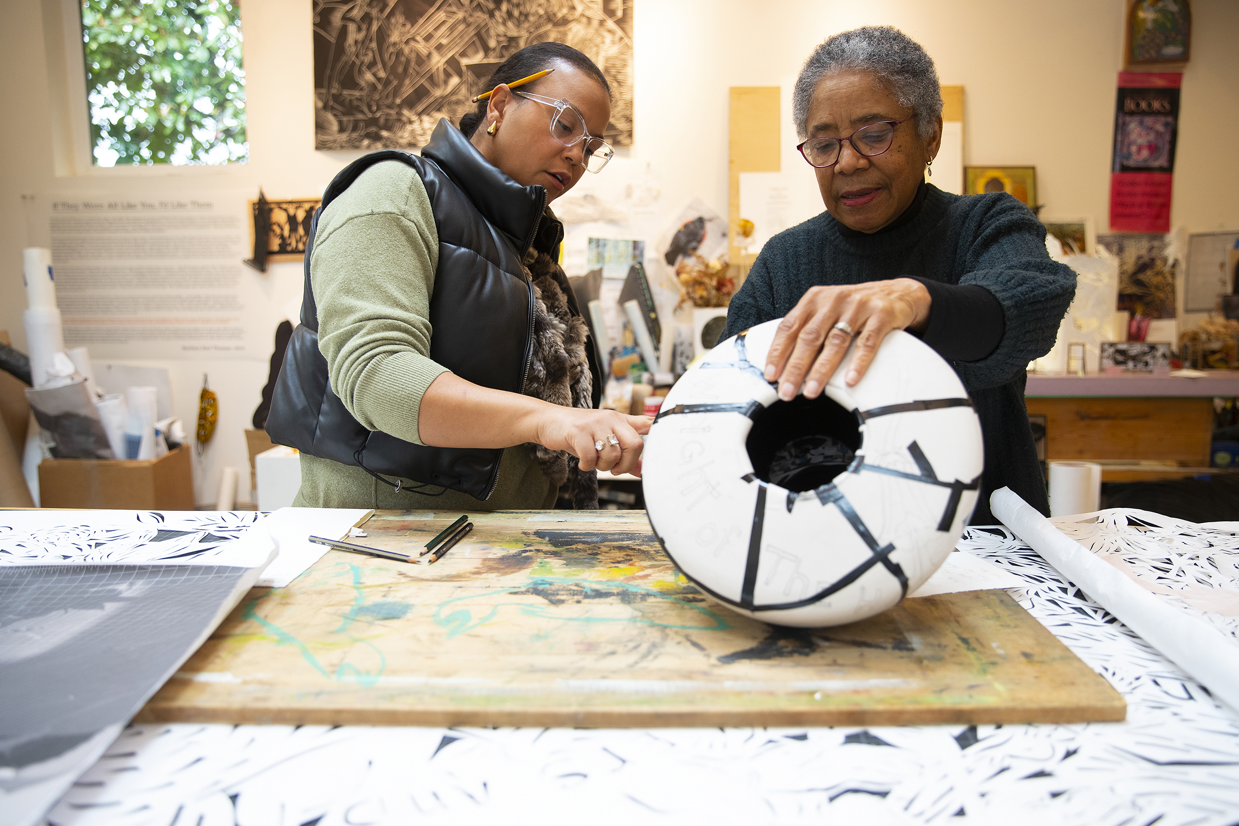 caption: Artist Barbara Earl Thomas, right, shows writer Leilani Lewis, left, one of her artworks in progress at her studio on Wednesday, February 18, 2026, in Columbia City. 