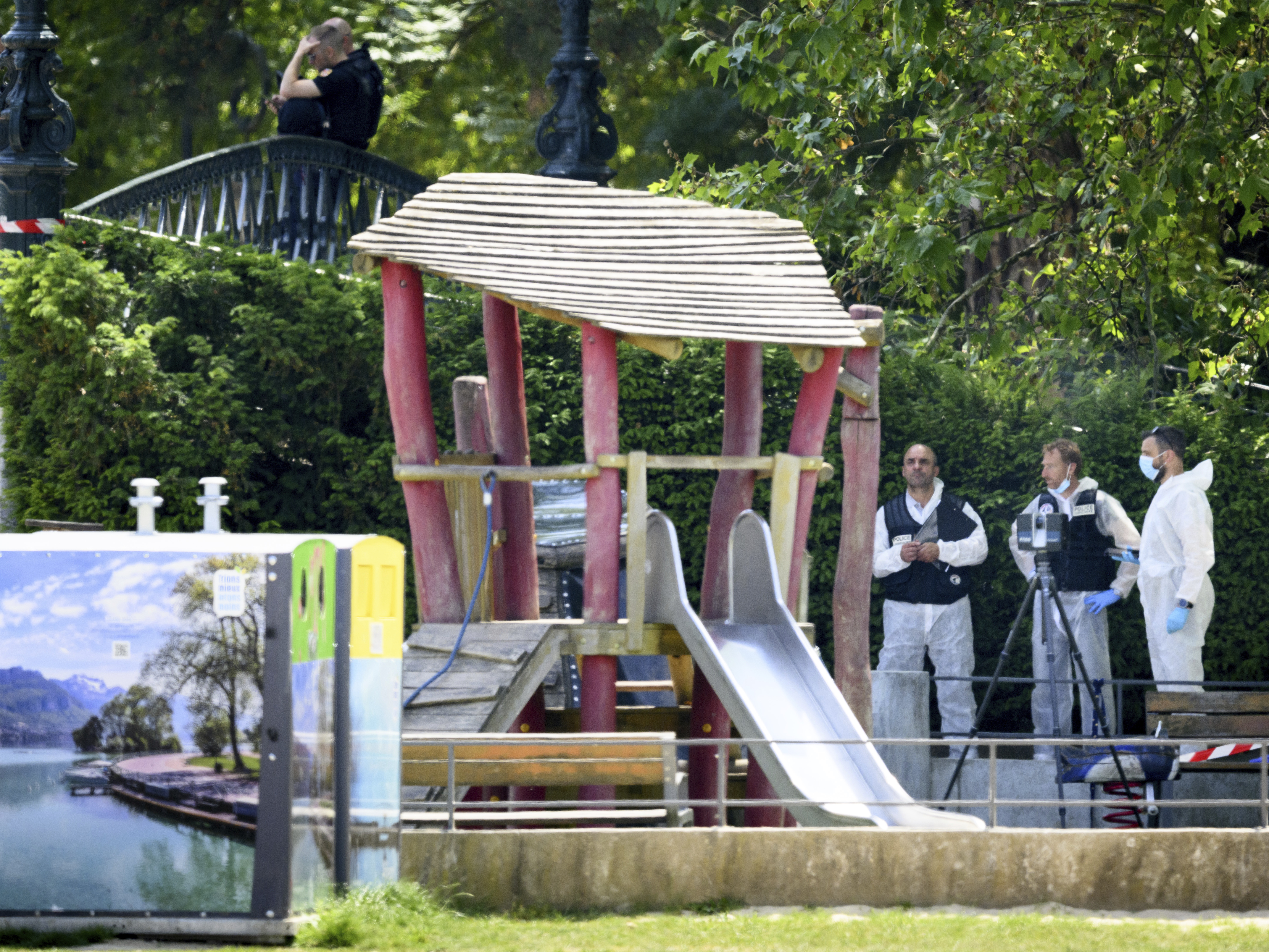 caption: Security forces gather in a playground at the scene of knife attack in Annecy, a town in the French Alps, on Thursday.