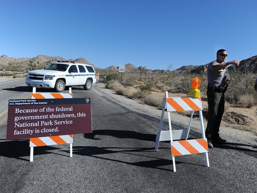 caption: A U.S. park ranger gives a visitor suggestions of other nearby places he can visit while Joshua Tree National Park was shutdown in 2013.