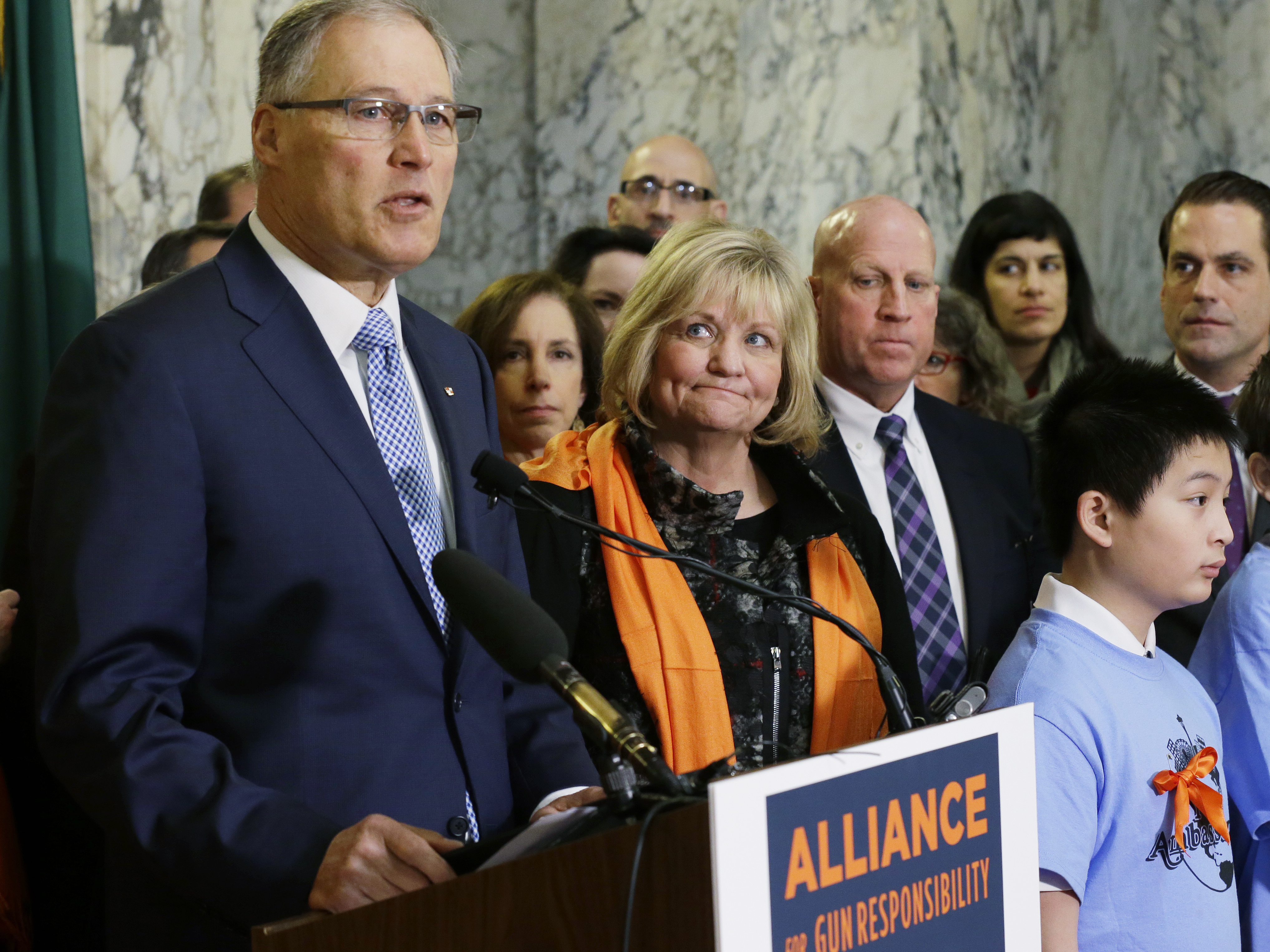 caption: Washington Gov. Jay Inslee speaks in support of firearm restrictions in 2017, as his wife, Trudi, looks on. The initiative passed, but some Washington state sheriffs are refusing to enforce all the measures.