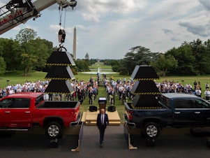 caption: Then-President Donald Trump walks past weights and a crane after delivering remarks at the White House in July 2020.