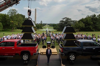 caption: Then-President Donald Trump walks past weights and a crane after delivering remarks at the White House in July 2020.
