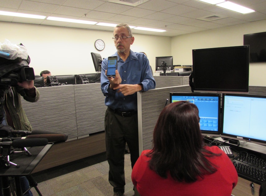 caption: King County can now accept text messages to 9-1-1. Jim House, who is deaf, shows how he could report a crime to Michele Torresdiaz, in red. 
