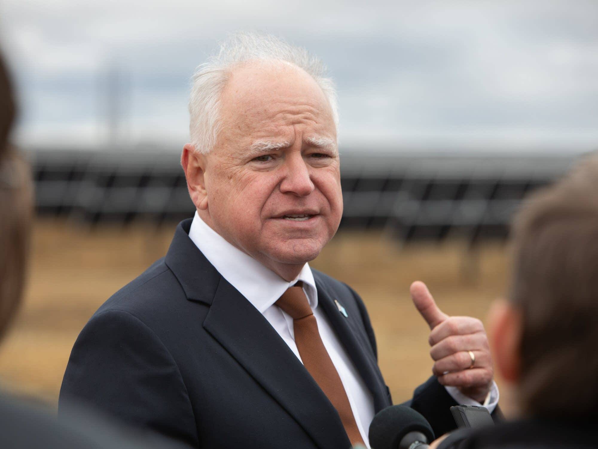 caption: Minn Gov. Tim Walz answers reporters' questions Tuesday, Nov. 19, 2024 after a ceremony marking the completion of Xcel Energy's Sherco Solar 1 project northwest of Becker, Minn. The project is expected to provide power for as many as 150,000 homes.