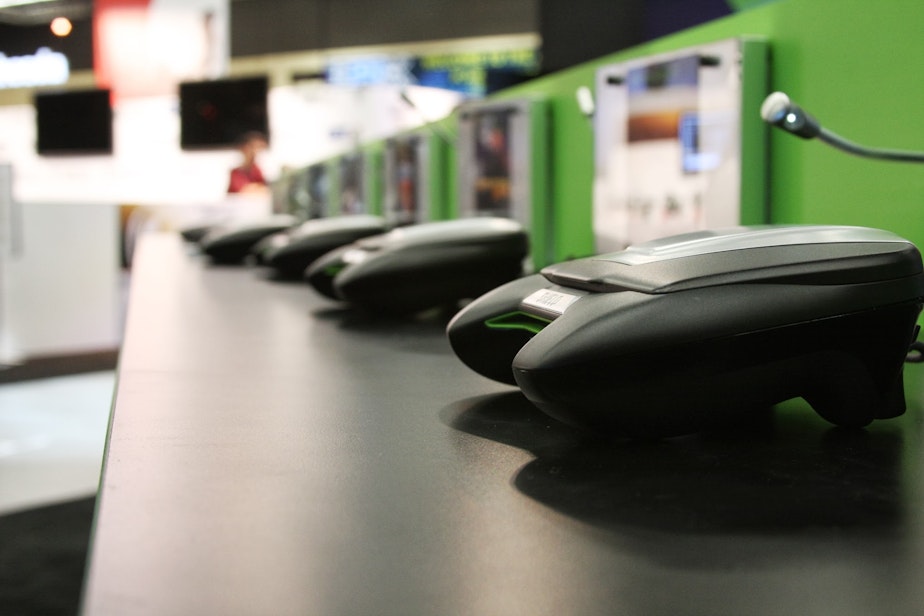 caption: Xbox controllers line a table at PAX in Seattle. 