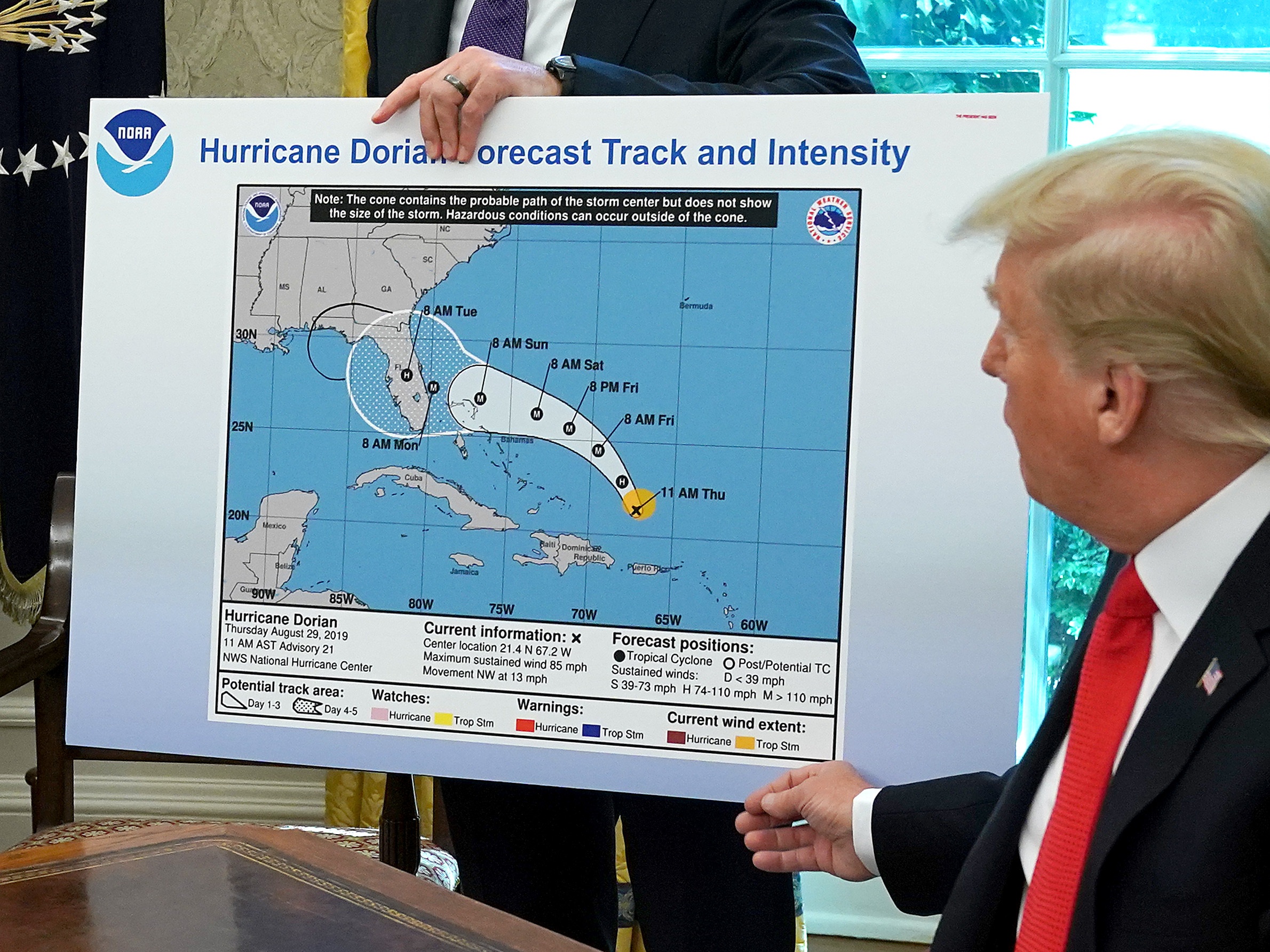 caption: President Trump references a map while talking to reporters about Hurricane Dorian on Sept. 4, 2019. The map appears to have been altered by a black marker to extend the hurricane's range to include Alabama.