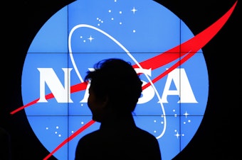 caption: South Korean President Park Geun-hye walks past a NASA logo during a tour at the agency's Goddard Space Flight Center in Greenbelt, Md.
