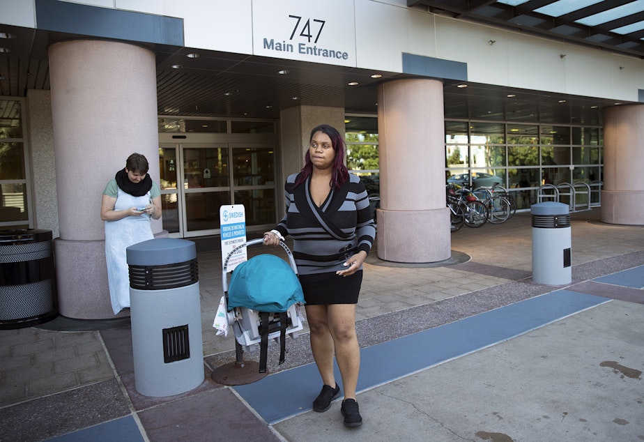 caption: Tiffany Hicks carries her newborn son, Elijah, as she leaves Swedish First Hill Birth Center on Thursday, August 31, 2017, in Seattle.
