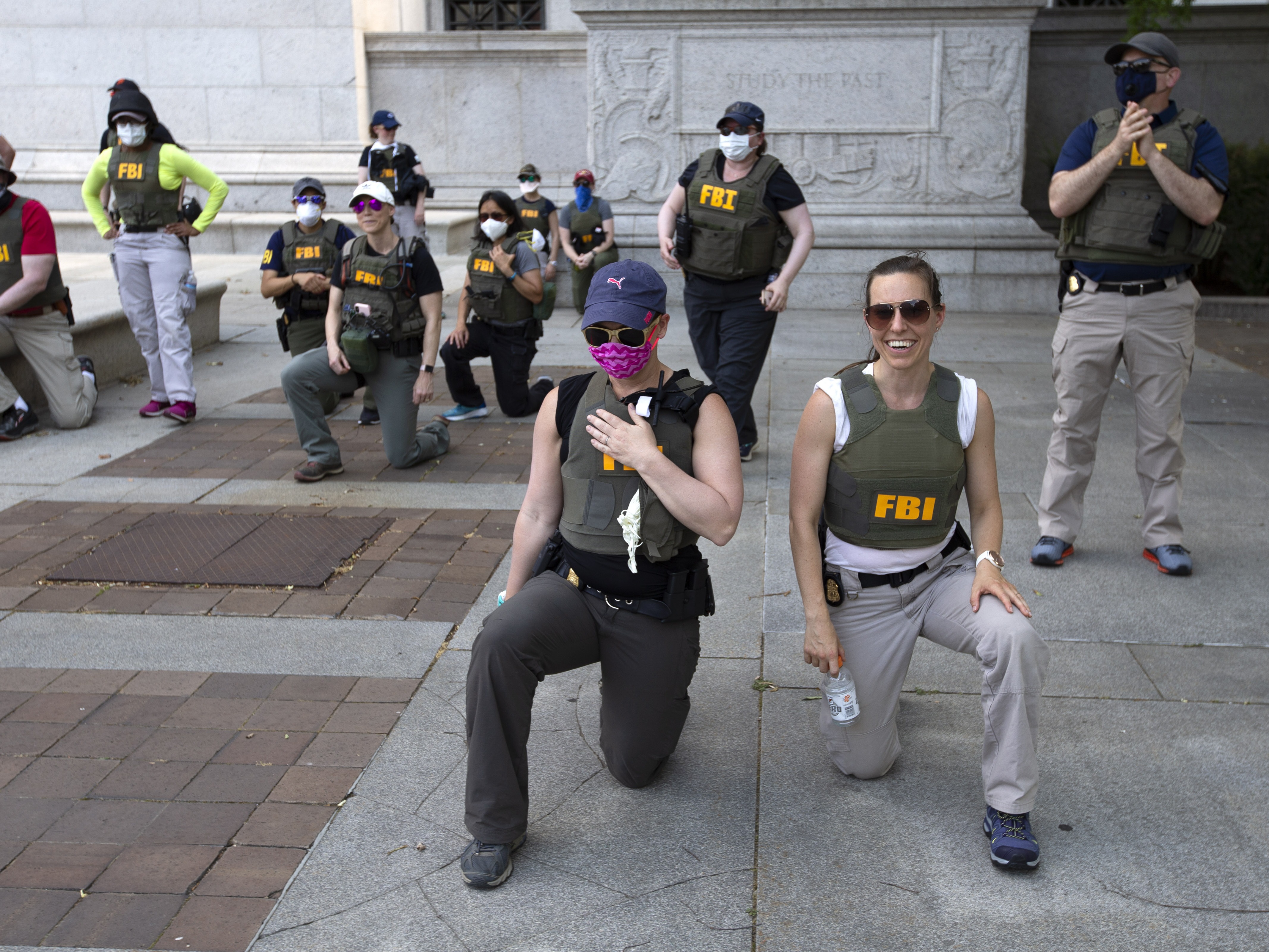 caption: FBI officers are seen here taking a knee as demonstrators marched in June 2020, in Washington, D.C., during a protest over the death of George Floyd, a Black man who died after a police officer kneeled on his neck for several minutes.