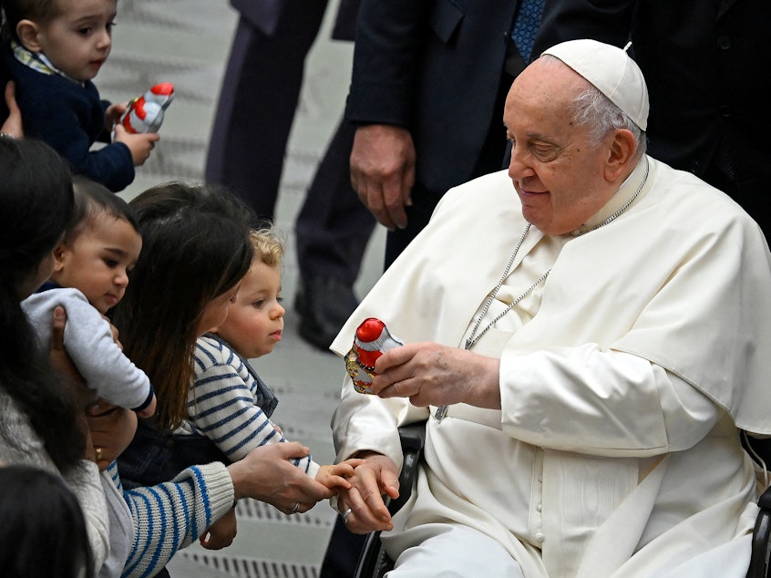 caption: Pope Francis distributes sweets to children during the weekly general audience in Paul VI hall at the Vatican on Jan. 3.