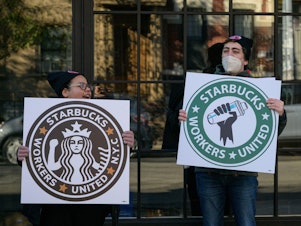 caption: Starbucks workers strike outside a Starbucks coffee shop on Nov. 17, 2022, in Brooklyn, protesting the company's anti-union activities.