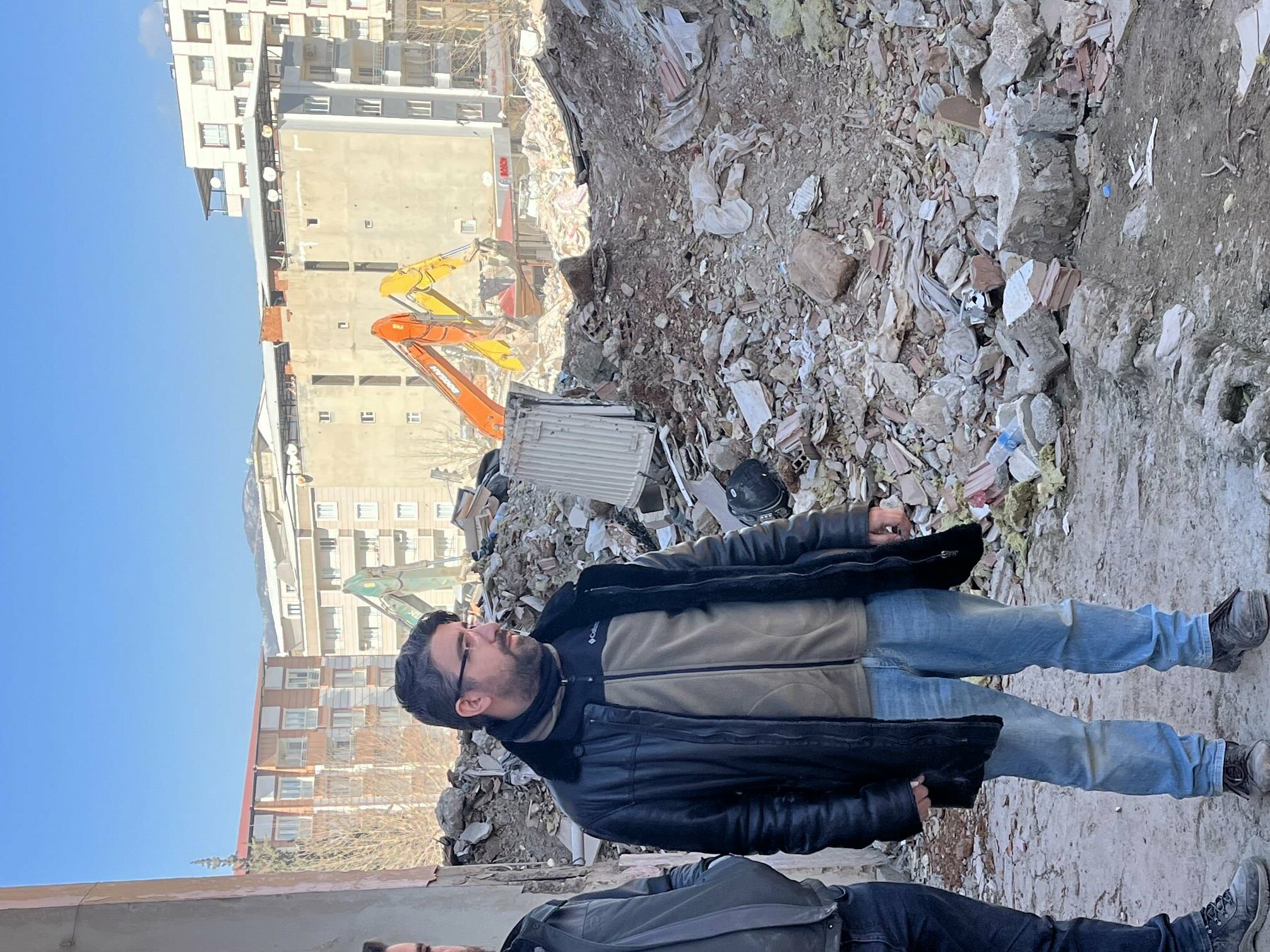 caption: Ali Kafadenk (left) and his brother, Abdullah, look at the rubble of Ali's apartment in Islahiye, Turkey. Ali and his wife MerveÂ survived the earthquake Feb 6.