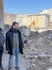 caption: Ali Kafadenk (left) and his brother, Abdullah, look at the rubble of Ali's apartment in Islahiye, Turkey. Ali and his wife MerveÂ survived the earthquake Feb 6.