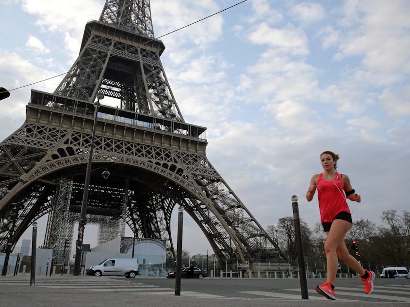 caption: A jogger runs past the Eiffel Tower on Wednesday in Paris.
