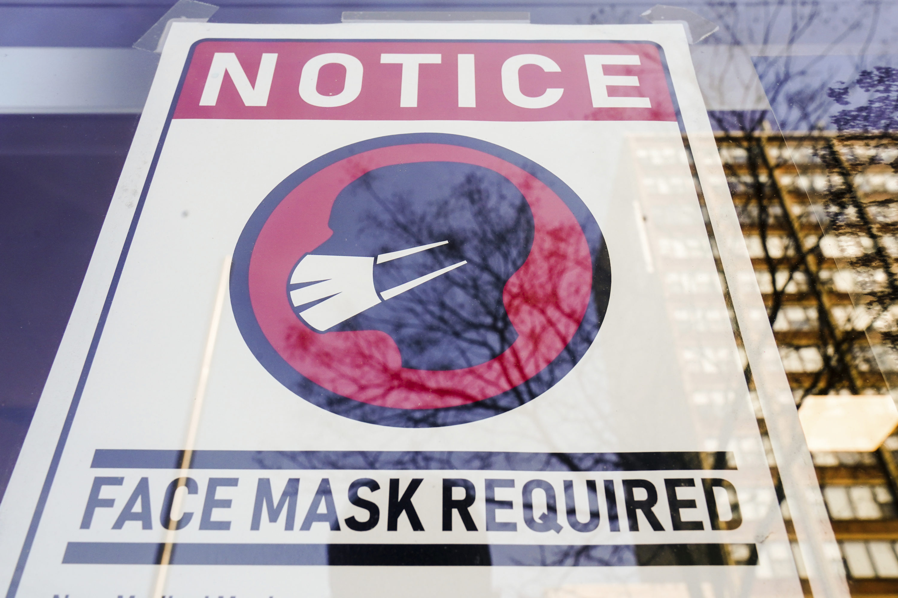 caption: A sign requiring masks as a precaution against the spread of the coronavirus on a store front in Philadelphia, is seen Feb. 16, 2022. (Matt Rourke/AP)