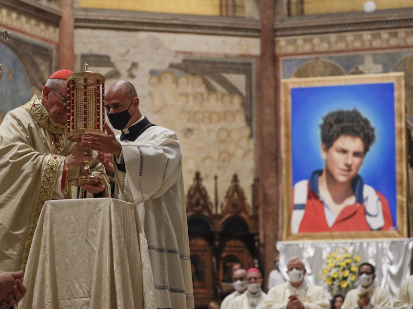 caption: Cardinal Agostino Vallini, left, holds a relic of 15-year-old Carlo Acutis, an Italian boy who died in 2006 of leukemia, during his beatification ceremony celebrated in the St. Francis Basilica, in Assisi, Italy, on Saturday.