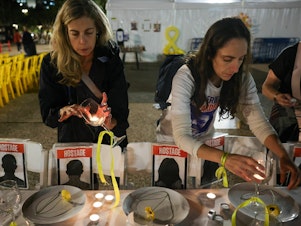 caption: Women prepare a symbolic dinner table during a rally in Tel Aviv, Israel, on Tuesday, demanding the release of Israelis held hostage in the Gaza Strip since the Oct. 7 attack by Hamas militants.