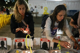 caption: Women prepare a symbolic dinner table during a rally in Tel Aviv, Israel, on Tuesday, demanding the release of Israelis held hostage in the Gaza Strip since the Oct. 7 attack by Hamas militants.