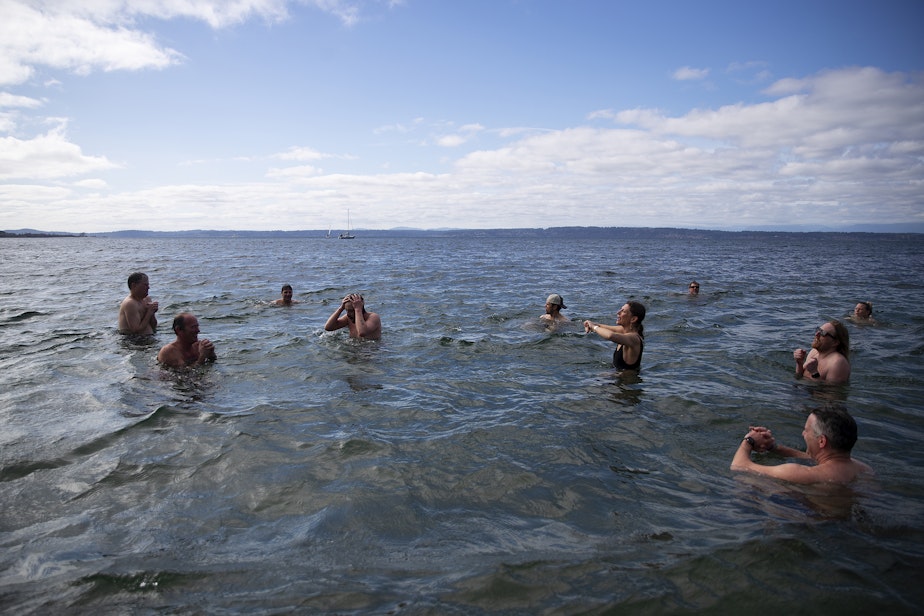 caption: KAVU employees cold plunge in the Puget Sound on Friday, March 7, 2025, at Golden Gardens Park in Seattle.