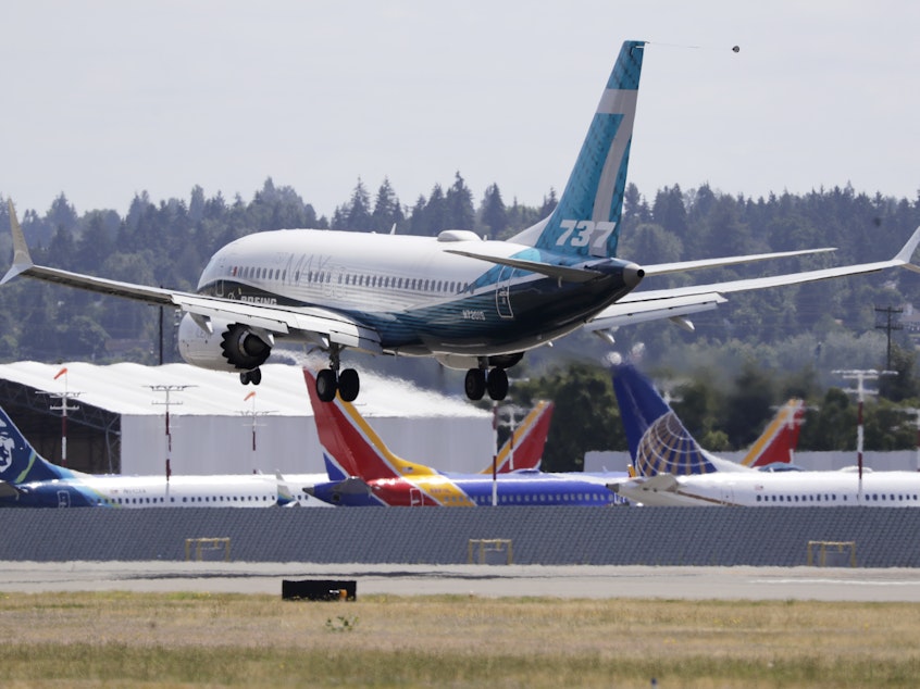 caption: A Boeing 737 Max heads to a landing past grounded 737 Max aircraft at Boeing Field following a test flight Monday in Seattle. The jet took off from Boeing Field earlier in the day, the start of three days of re-certification test flights that mark a step toward returning the aircraft to passenger service.