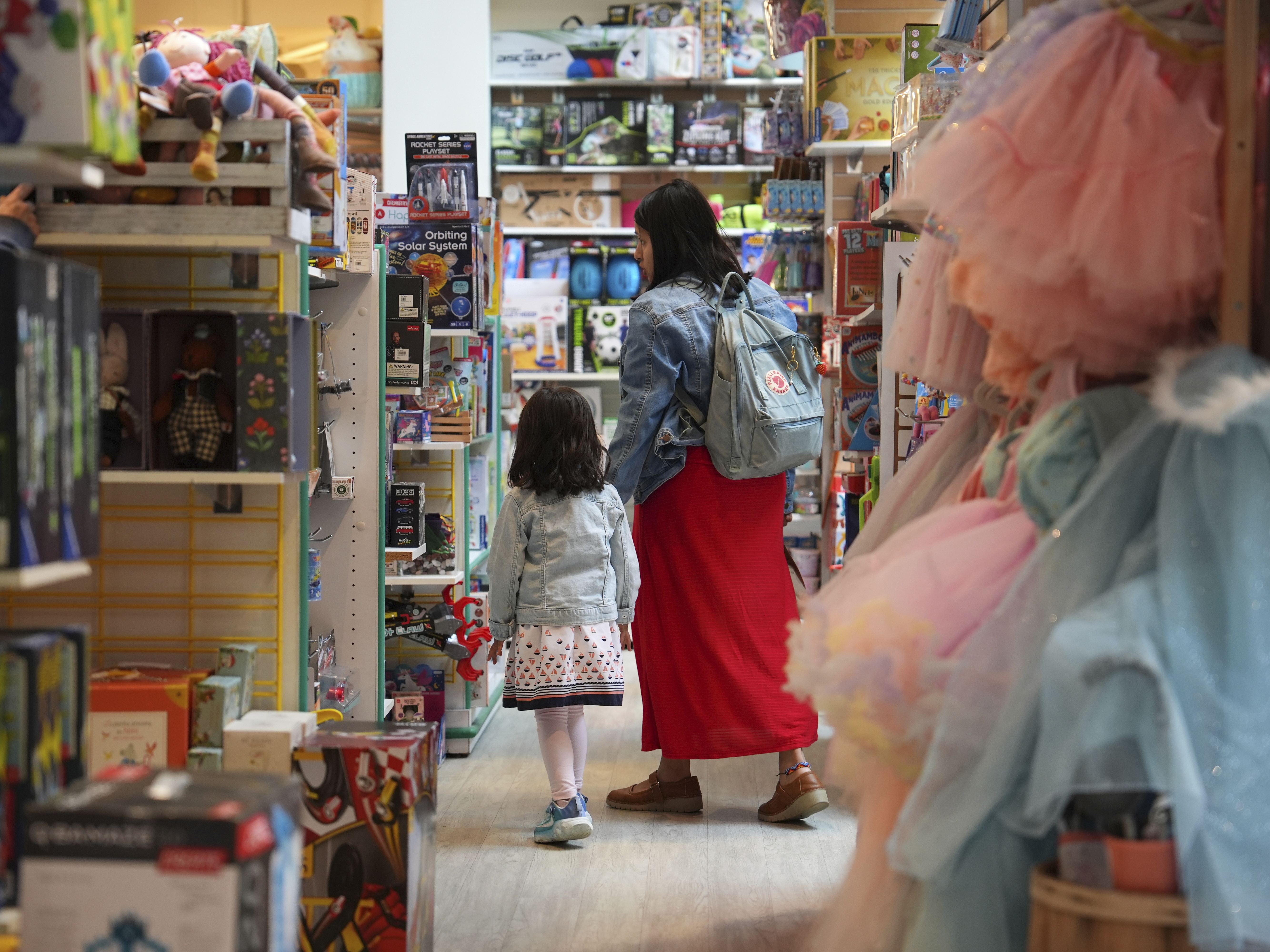 caption: A family shops in a toy store in Princeton, N.J.