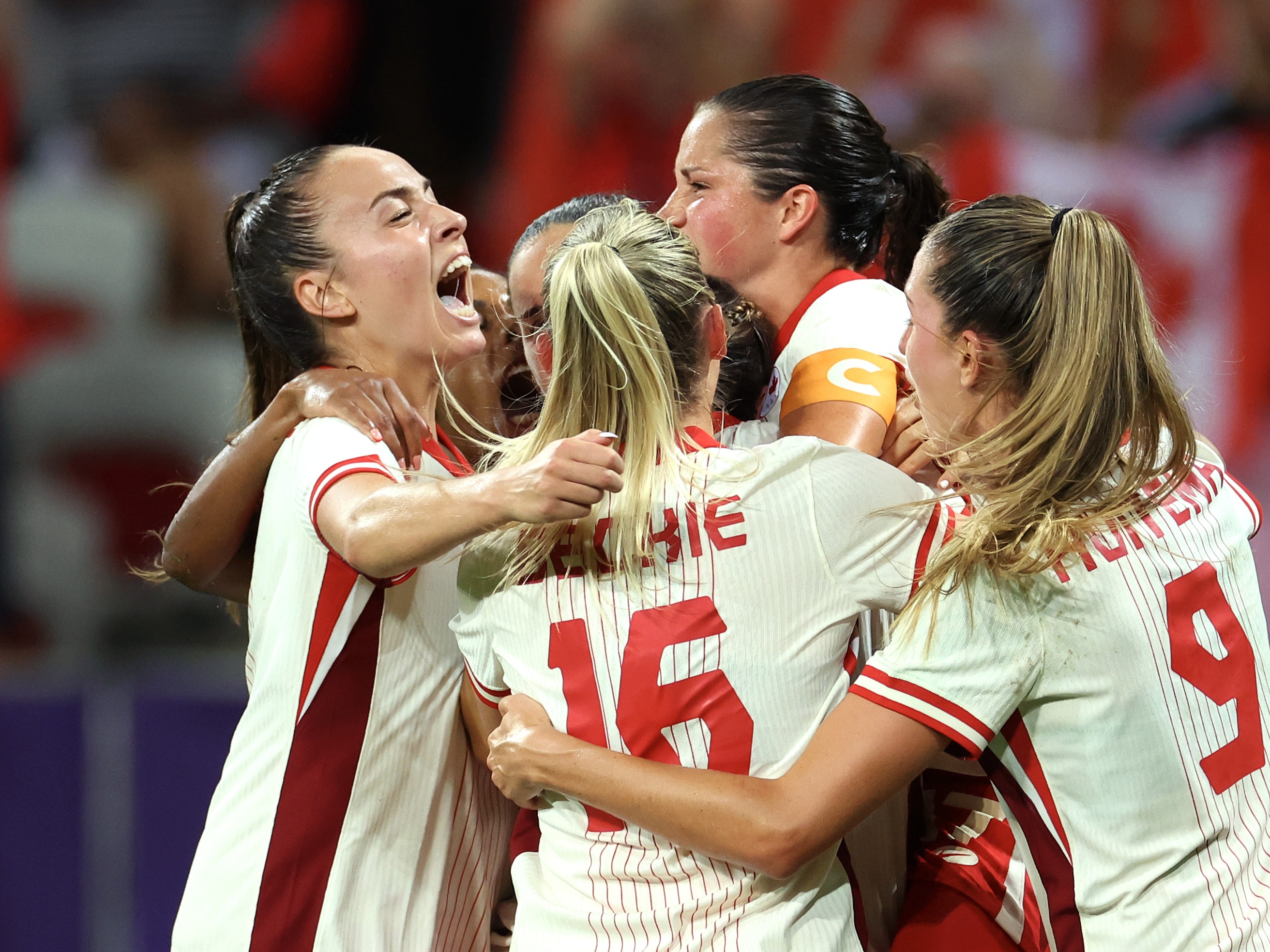 caption: The Canadian women's soccer team celebrates during its win over Colombia Wednesday. The team has advanced into the Olympic quarterfinals amid an ongoing spying scandal involving the team's now-suspended head coach. 